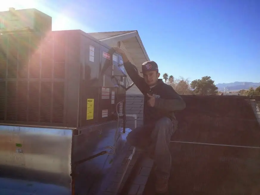 HVAC technician performing Boiler Repair on a rooftop unit in Chippewa